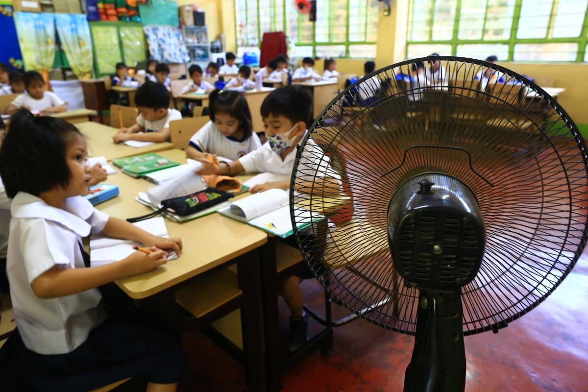 Students of the Justo Lukban Elementary School in Paco, Manila gather near an electric fan during a face-to-face class on April 2, 2024. PHOTO BY MIKE ALQUINTO